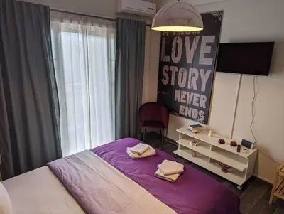 a bedroom with a purple bed with a love story never ends at Cozy apartm.near Metro Ag.Marina in Athens
