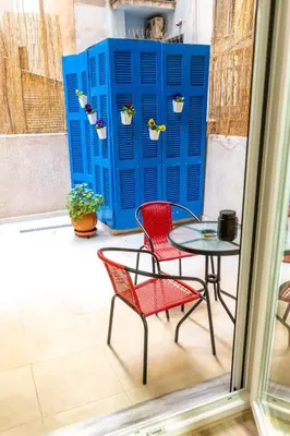 a patio with two chairs and a table and a blue shed at Oasis in the centre in Athens