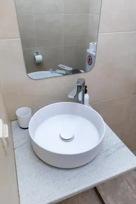 a white sink in a bathroom with a mirror at Oasis in the centre in Athens