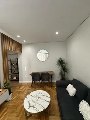 a living room with a black couch and a table at Mihaela-Andreea Luxury House in Athens