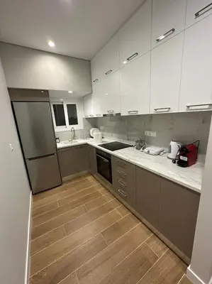 a kitchen with white cabinets and a wooden floor at Mihaela-Andreea Luxury House in Athens