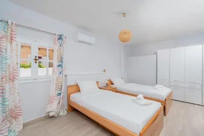 two beds in a room with white walls at Zen Hilltop by A&D Properties in Porto Rafti