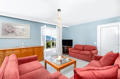 a living room with two red chairs and a table at Zen Hilltop by A&D Properties in Porto Rafti