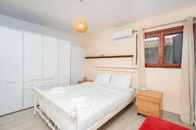 a white bedroom with a white bed and a window at Zen Hilltop by A&D Properties in Porto Rafti