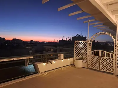 a balcony with a view of the city at dusk at Quiet house-Athens Center 100 meters balcony on the top floor in Athens