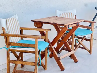 a wooden table and two chairs sitting next to a table and chairs at Quiet house-Athens Center 100 meters balcony on the top floor in Athens