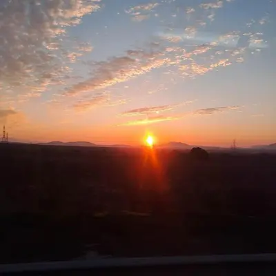 a sunset in a field with the sun in the sky at Quiet house-Athens Center 100 meters balcony on the top floor in Athens
