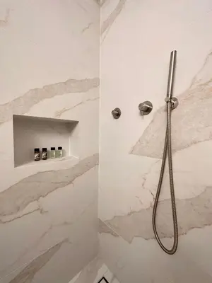 a bathroom with a shower with marble walls at Sunny Apartment in Koukaki - Excellent spot in Athens
