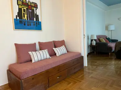 a couch with three pillows on it in a living room at Sunny Apartment in Koukaki - Excellent spot in Athens