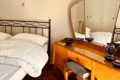 a bedroom with a bed and a mirror on a dresser at Grandma's Apartment in Athens