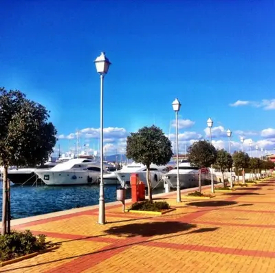 a row of street lights next to a marina with boats at Seaside Apartment by Flisvos Marina in Athens