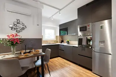 a kitchen with stainless steel appliances and a table at Seaside Apartment by Flisvos Marina in Athens