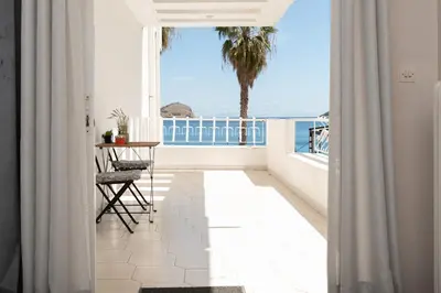 a room with a balcony with a view of the ocean at Bluehouse in Porto Rafti