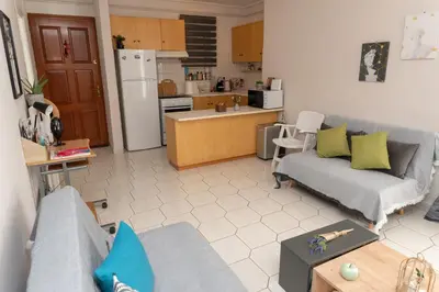 a living room with a couch and a kitchen at Bluehouse in Porto Rafti
