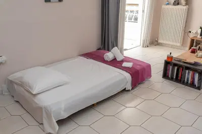 a bedroom with a large bed with a purple blanket at Bluehouse in Porto Rafti