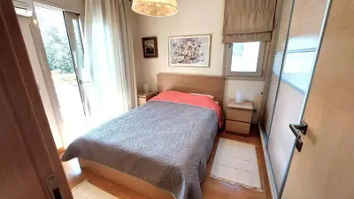 a small bedroom with a bed and a window at Luxury apartment SEA HELM with private swimming pool and BBQ in Lagonissi