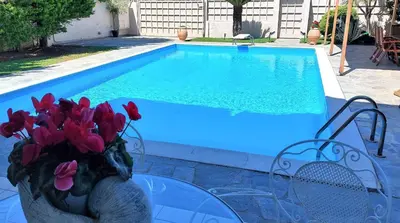 a vase of flowers on a glass table next to a swimming pool at Luxury apartment SEA HELM with private swimming pool and BBQ in Lagonissi