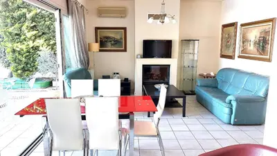a living room with a table and a couch at Luxury apartment SEA HELM with private swimming pool and BBQ in Lagonissi