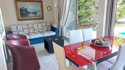 a living room with a red table and chairs at Luxury apartment SEA HELM with private swimming pool and BBQ in Lagonissi