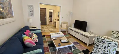 a living room with a blue couch and a tv at Syntagma Plaka Getaway Apartment in Athens