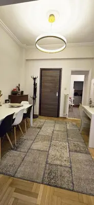 a living room with a table and a rug at Syntagma Plaka Getaway Apartment in Athens