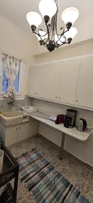 a kitchen with a table and a chandelier at Syntagma Plaka Getaway Apartment in Athens