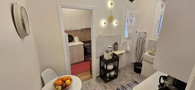 a small kitchen with a bowl of fruit on a table at Syntagma Plaka Getaway Apartment in Athens