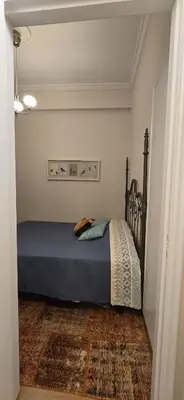 a bedroom with a bed with a blue comforter at Syntagma Plaka Getaway Apartment in Athens