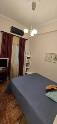 a bedroom with a large bed and a television at Syntagma Plaka Getaway Apartment in Athens