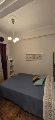 a bedroom with a large bed with a blue blanket at Syntagma Plaka Getaway Apartment in Athens