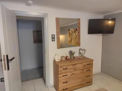 a bedroom with a wooden dresser and a mirror at Anastasia's apartment with yard in Athens