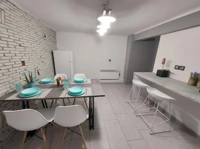 a dining room with a table and white chairs at Anastasia's apartment with yard in Athens