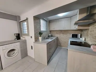 a kitchen with a sink and a washing machine at Anastasia's apartment with yard in Athens