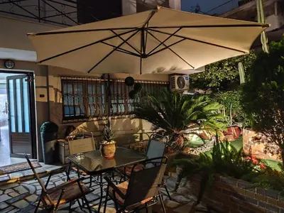 a patio with an umbrella and a table and chairs at Anastasia's apartment with yard in Athens
