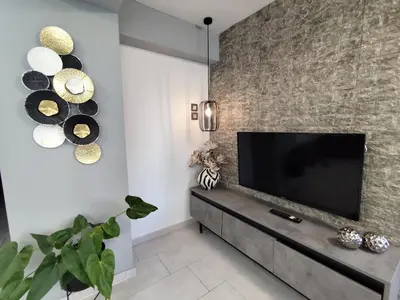 a living room with a flat screen tv on a wall at Anastasia's apartment with yard in Athens