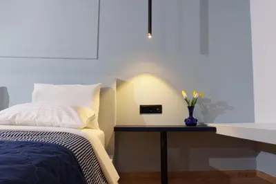a bedroom with a bed and a table with a vase of flowers at Sani Deluxe Suites Home- Monastiraki Square - Brand New Home in Athens