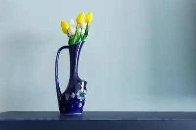 a blue vase with yellow flowers in it at Sani Deluxe Suites Home- Monastiraki Square - Brand New Home in Athens