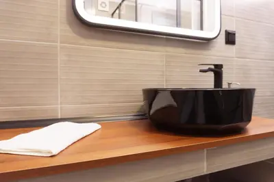 a black sink on a wooden counter in a bathroom at Sani Deluxe Suites Home- Monastiraki Square - Brand New Home in Athens