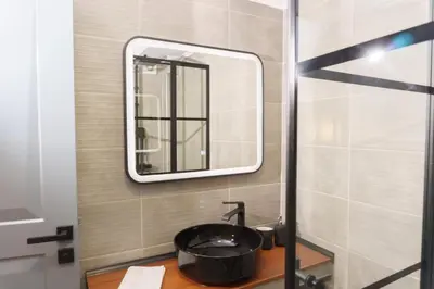 a bathroom with a sink and a mirror at Sani Deluxe Suites Home- Monastiraki Square - Brand New Home in Athens