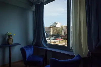 a window with two chairs and a view of a city at Sani Deluxe Suites Home- Monastiraki Square - Brand New Home in Athens