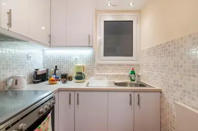 a kitchen with white cabinets and a sink at Athenslander Acropolis view in Athens