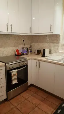 a kitchen with white cabinets and an oven at Athenslander Acropolis view in Athens