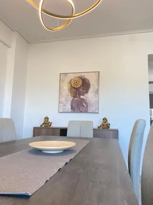 a dining room with a table and a painting on the wall at Porto Rafti Dream Complex & Retreat in Porto Rafti