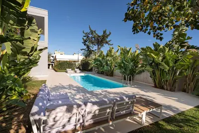 a swimming pool with two lounge chairs next to a house at Porto Rafti Dream Complex & Retreat in Porto Rafti