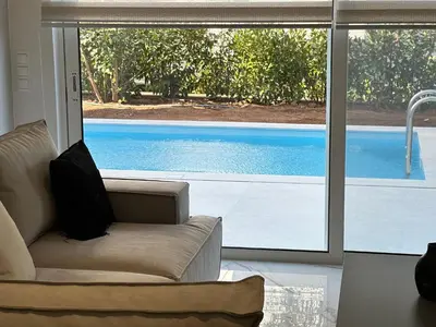 a living room with a couch and a large window at Porto Rafti Dream Complex & Retreat in Porto Rafti