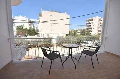 a balcony with a table and chairs and a view of a city at K&C Rooms- Apartments in Markopoulo