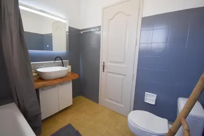 a bathroom with a white sink and a toilet at K&C Rooms- Apartments in Markopoulo