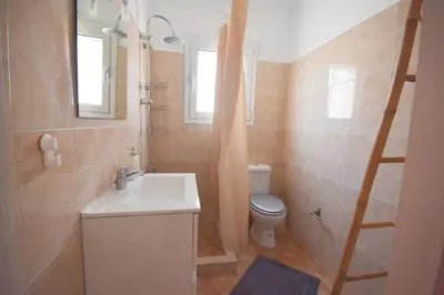 a bathroom with a white sink and a toilet at K&C Rooms- Apartments in Markopoulo