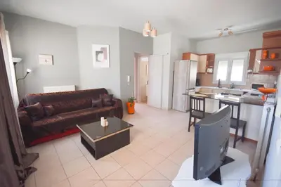 a living room with a couch and a tv in it at K&C Rooms- Apartments in Markopoulo
