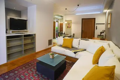 a living room with a white couch and a tv at Little gem in the historical center of Athens in Athens